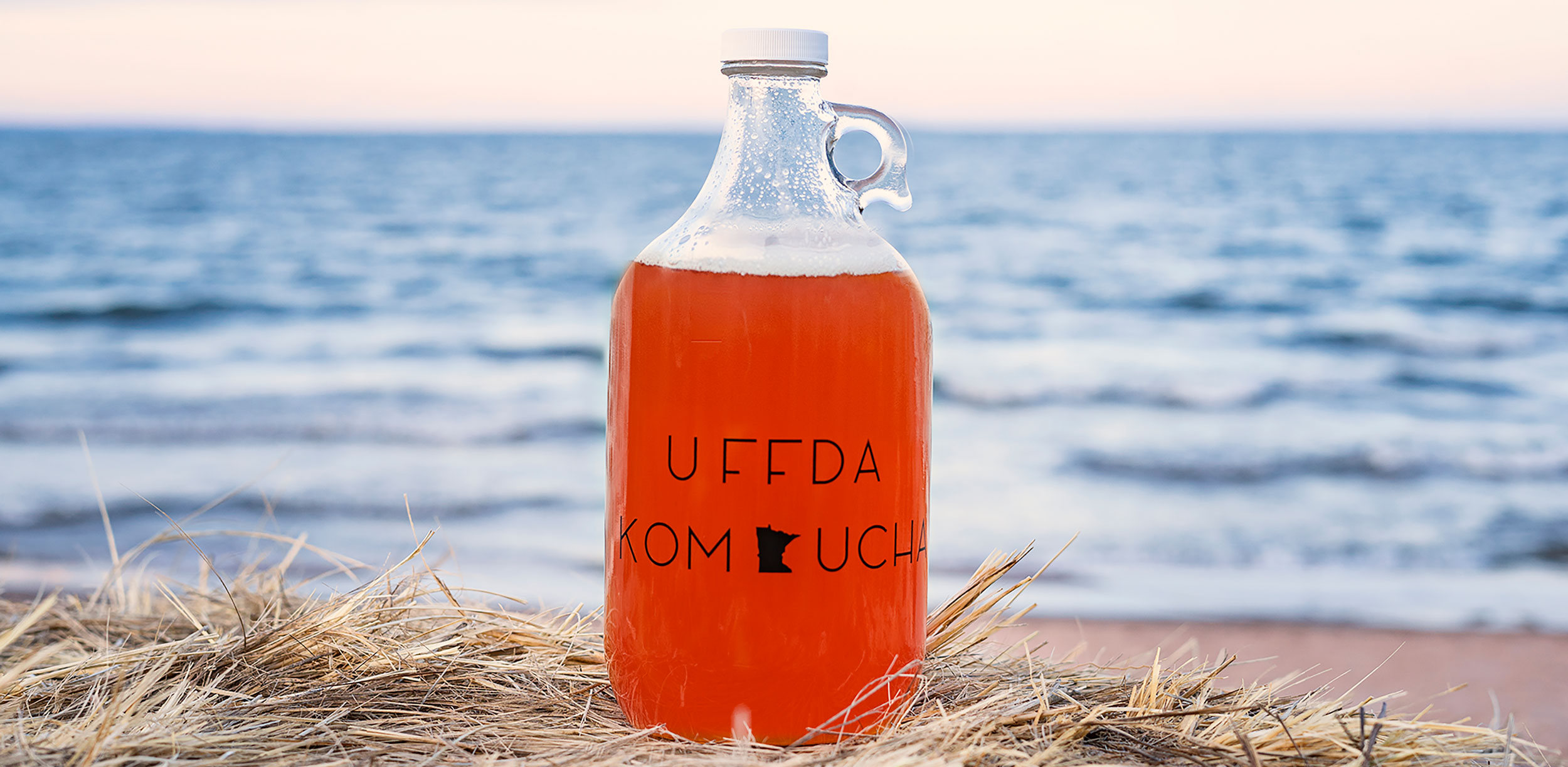 Bottle of kombucha on a beach